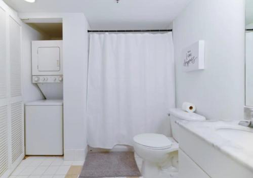 a white bathroom with a toilet and a sink at 2BD Condo At Brickell With Bay View in Miami