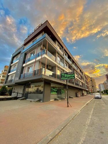 un gran edificio con un letrero de la calle delante de él en Palmiye Gold, en Çiftlikköy