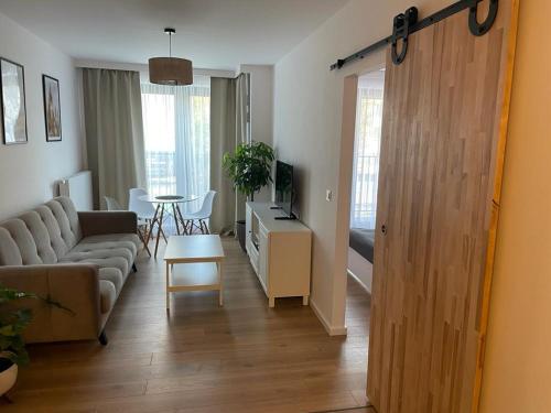 a living room with a couch and a table at The Botanic Corner Apartment in Wrocław