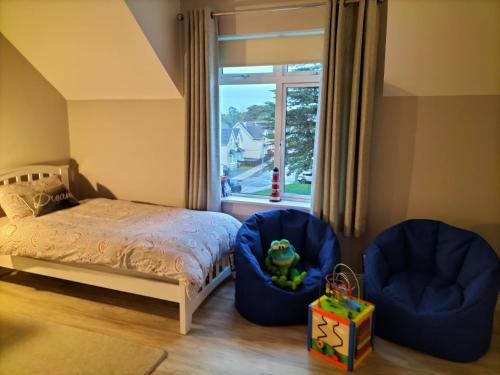 a bedroom with two chairs and a bed and a window at Dolmen Apartment Carlingford Lough,Omeath in Ó Méith