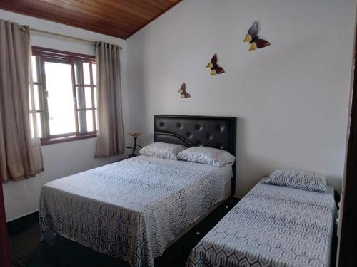 1 dormitorio con 2 camas y ventana en Uma PAUSA na sua vida, com: sol, praia e sossego!, en Cabo Frío