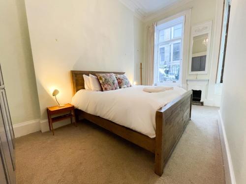 1 Bed Character Filled Glasgow Apartment في غلاسكو: غرفة نوم بسرير كبير ونافذة