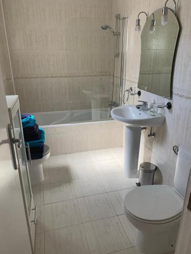 a bathroom with a toilet and a sink and a tub at Casa Estrella in Mojácar