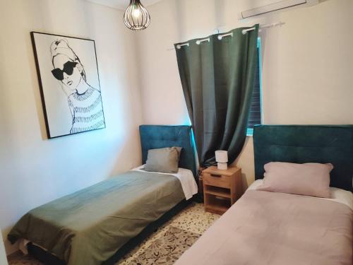 um quarto com 2 camas e uma janela com uma cortina em Akrokorinthos View House em Kórinthos