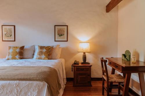 a bedroom with a bed and a desk with a lamp at Pousada Pedra Azul in Pedra Azul