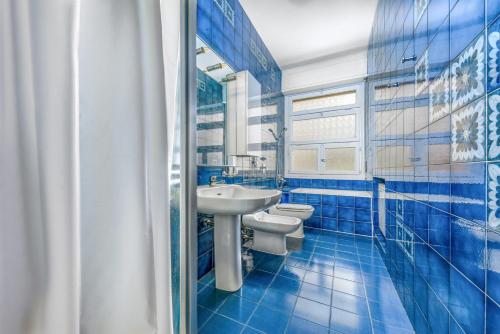Baño azul con lavabo y 2 aseos en Casa da Suite Lukema en Milán