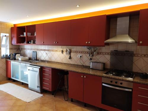 een keuken met rode kasten en witte apparaten bij Country Villa work&relax in Lagos