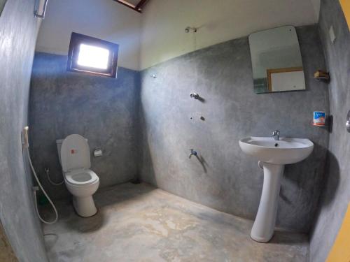 ein Badezimmer mit Toilette und Waschbecken in der Unterkunft New Star Light in Mirissa