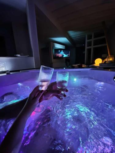 a person holding two wine glasses in a swimming pool at HOME 3 Luxury Suite in Bisceglie