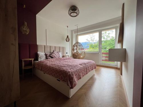 a bedroom with a large bed and a window at Apartament Partykularz z tarasem i widokiem na Śnieżkę in Karpacz