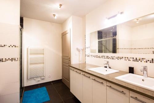 La salle de bains est pourvue de 2 lavabos et d'un miroir. dans l'établissement Villa SAVANE, à Arcachon
