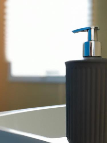a black soap dispenser sitting on top of a counter at Slow M'Ocean Villa in Pataias