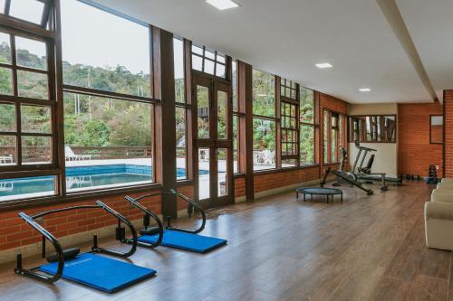 a gym with a swimming pool and pilates equipment at Pousada Pedra Azul in Pedra Azul