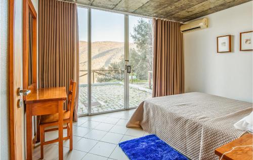 a bedroom with a bed and a desk and a window at Cozy Apartment In Freixo De Espada C With Outdoor Swimming Pool in Freixo de Espada à Cinta