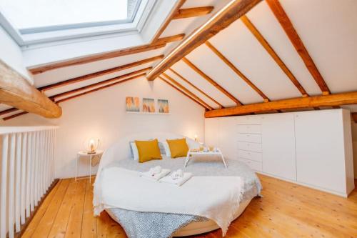 ein Schlafzimmer mit einem großen Bett in einem Zimmer mit Holzböden in der Unterkunft [Bellinzona] Rustico Loft a 5 Stelle con Netflix in Bellinzona