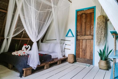 a bedroom with a bed with a mosquito net at Mao Mao surf in General Luna