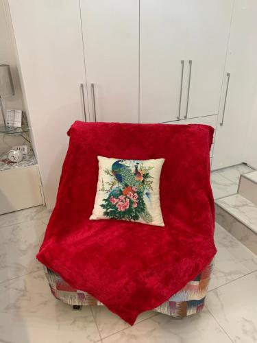 a red blanket sitting on a chair with a pillow at Cannes Apartment close to Congress Palace, Croisette, Beaches in Cannes