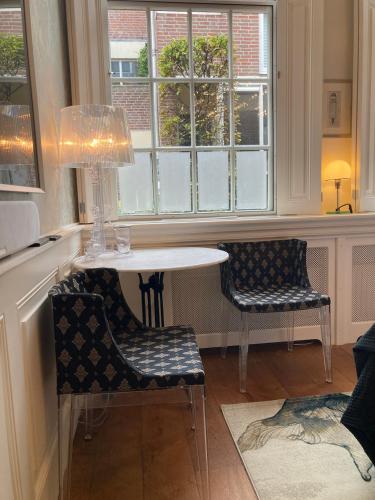 a table and two chairs in a room with a window at GuesthouseOne in Haarlem