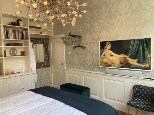 a bedroom with a bed and a tv on a wall at GuesthouseOne in Haarlem