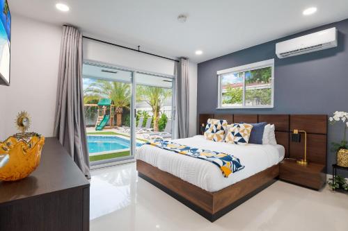 a bedroom with a bed and a pool at Stunning 5BR Heated Pool, Beach Access & Games L06 in Miami