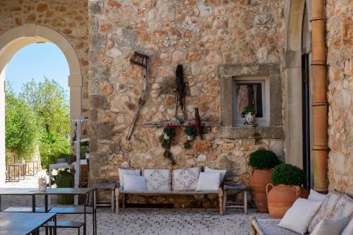 uma parede de pedra com um sofá num pátio em I Carusi Relais em Noto