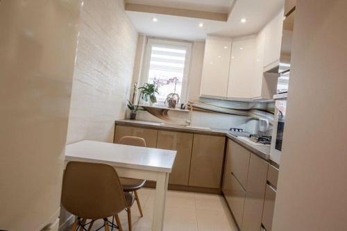 a small kitchen with a white table and chairs at Gdansk Old Town 2 room Apartment in Gdańsk