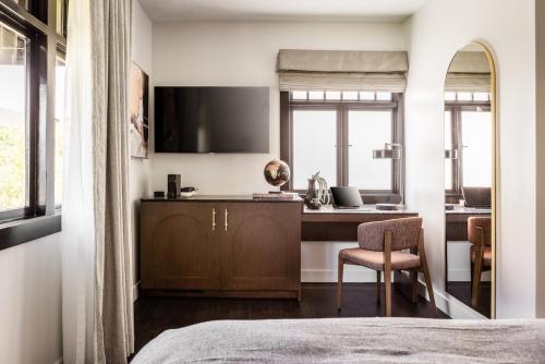 a bedroom with a bed and a desk and a chair at Orli La Jolla in San Diego
