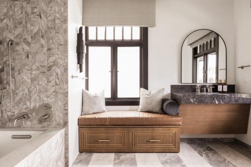 a bathroom with a tub and a sink and a mirror at Orli La Jolla in San Diego