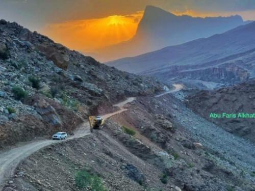 a car on a dirt road in the mountains at Jabal Shams bayt kawakib in Misfāh