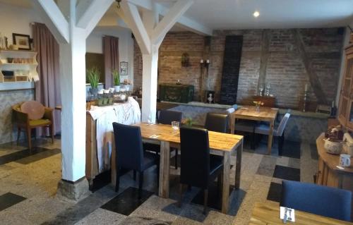 een eetkamer met tafels en stoelen en een bakstenen muur bij Das Gartenhaus in Neudorf