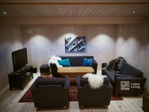 a living room with two couches and a tv at Grand cabin at Nesfjellet with lovely view, inddor Jacuzzi & sauna in Nes i Ådal