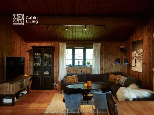 uma sala de estar com um sofá e uma mesa em Grand cabin Nesfjellet lovely view Jacuzzi sauna em Nes i Ådal