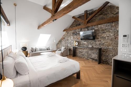 a bedroom with a white bed and a brick wall at Hôtel Boutique Ophelia - Par Aneyro in Quebec City