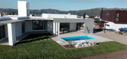 a house with a swimming pool in the yard at AIRES DEL LAGO, Los Molinos 2 in Potrero de Garay