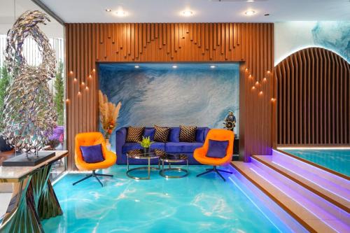a hotel lobby with a swimming pool and orange chairs at Hotel Mermaid Bangkok in Bangkok