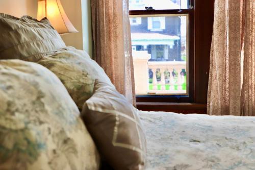 a bed with pillows and a window in a room at The Marshall House in Niagara Falls