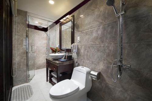 a bathroom with a toilet and a sink and a shower at Alisa Premier Cruise in Ha Long