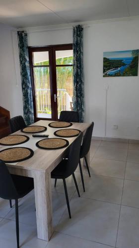 a room with a wooden table and chairs at Villa Creole alamanda 2 in Petite Île