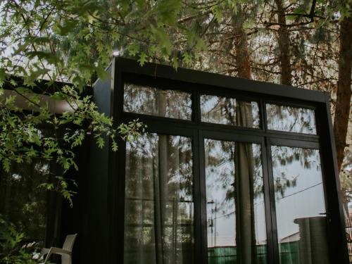 a black house with windows and trees at TWO Prefab Living - Luxury bungalows in Dullstroom