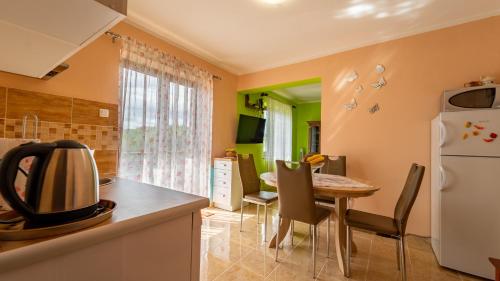 a kitchen and dining room with a table and a refrigerator at apartman NOA in Fužine