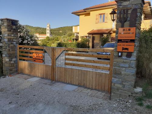 a wooden fence with a gate in front of a house at B & B Il Campanile in Perdifumo