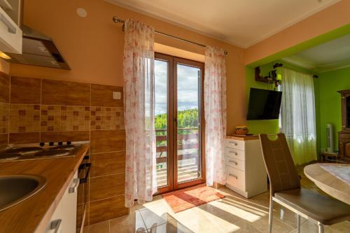 a kitchen with a sink and a large window at apartman NOA in Fužine