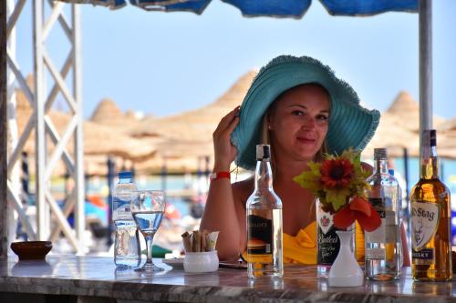 a woman sitting at a table with bottles of alcohol at Gafy Resort Aqua Park in Sharm El Sheikh