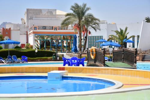 a swimming pool with a blue and white pool table and chairs at Gafy Resort Aqua Park in Sharm El Sheikh