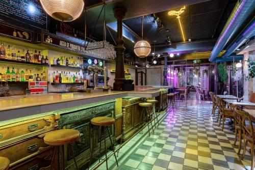 a bar with tables and stools in a room at Casa Gracia in Barcelona