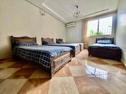 a room with three beds and a window at Fully equipped villa Near Agadir in Agadir