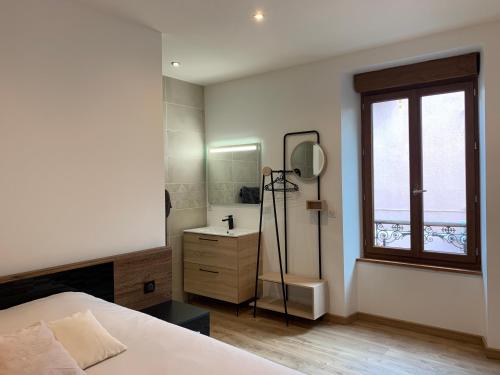 Schlafzimmer mit einem Bett, einem Waschbecken und einem Spiegel in der Unterkunft Chambre avec entrée indépendante in Lamastre