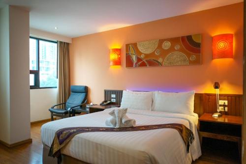 a hotel room with a bed with a stuffed animal on it at Hotel Mermaid Bangkok in Bangkok