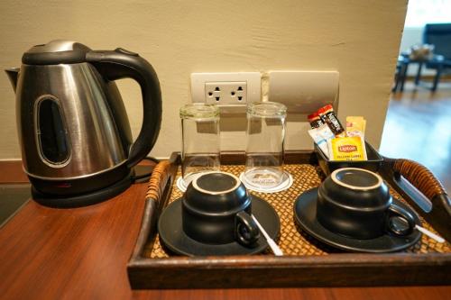 a tray with a tea kettle and cups on a table at Hotel Mermaid Bangkok in Bangkok