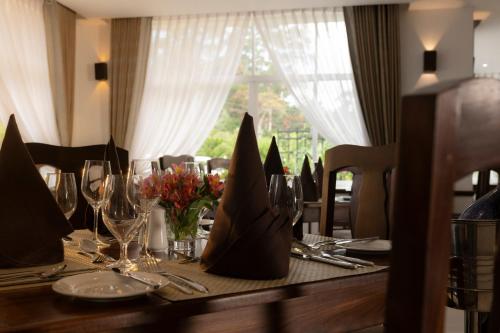 a table with a table set with glasses and flowers at Galway Heights Hotel in Nuwara Eliya